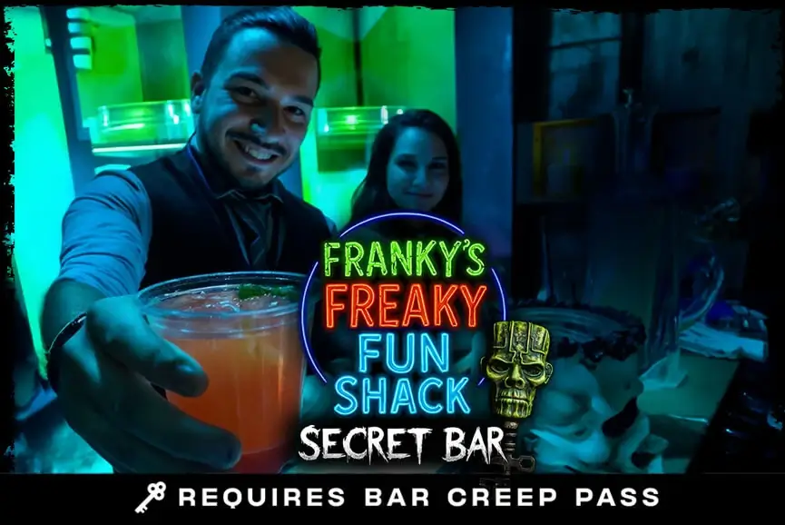Bartender presenting neon drink at Franky’s Freaky Fun Shack secret bar, Hush Haunted Attraction, Detroit haunted house.